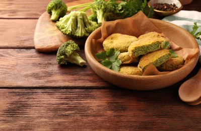 Tasty vegan cutlets and ingredients on wooden table, space for text