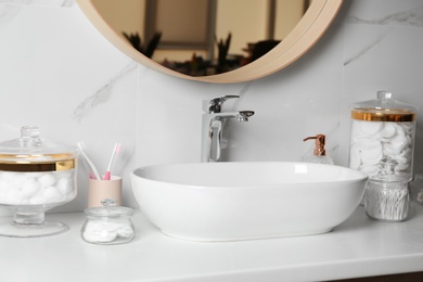 Photo of Cotton balls, swabs and pads on white countertop in bathroom