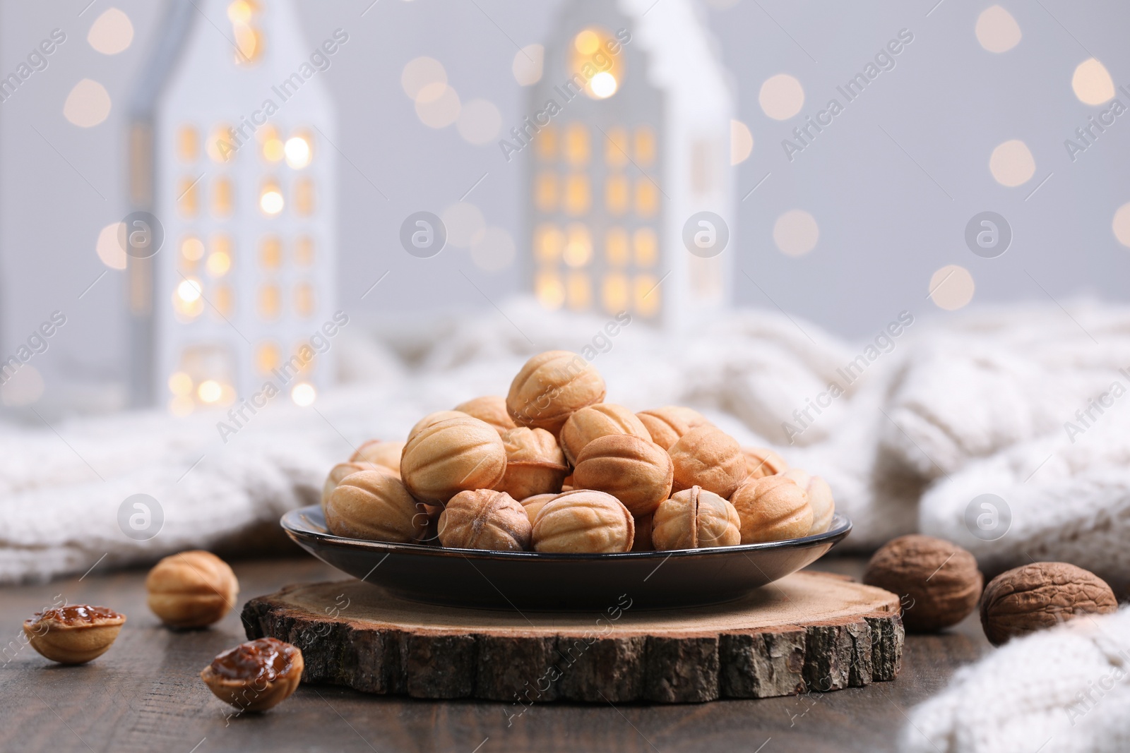 Photo of Homemade walnut shaped cookies with boiled condensed milk on wooden table. Bokeh effect