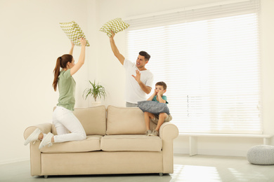 Happy family having pillow fight in living room