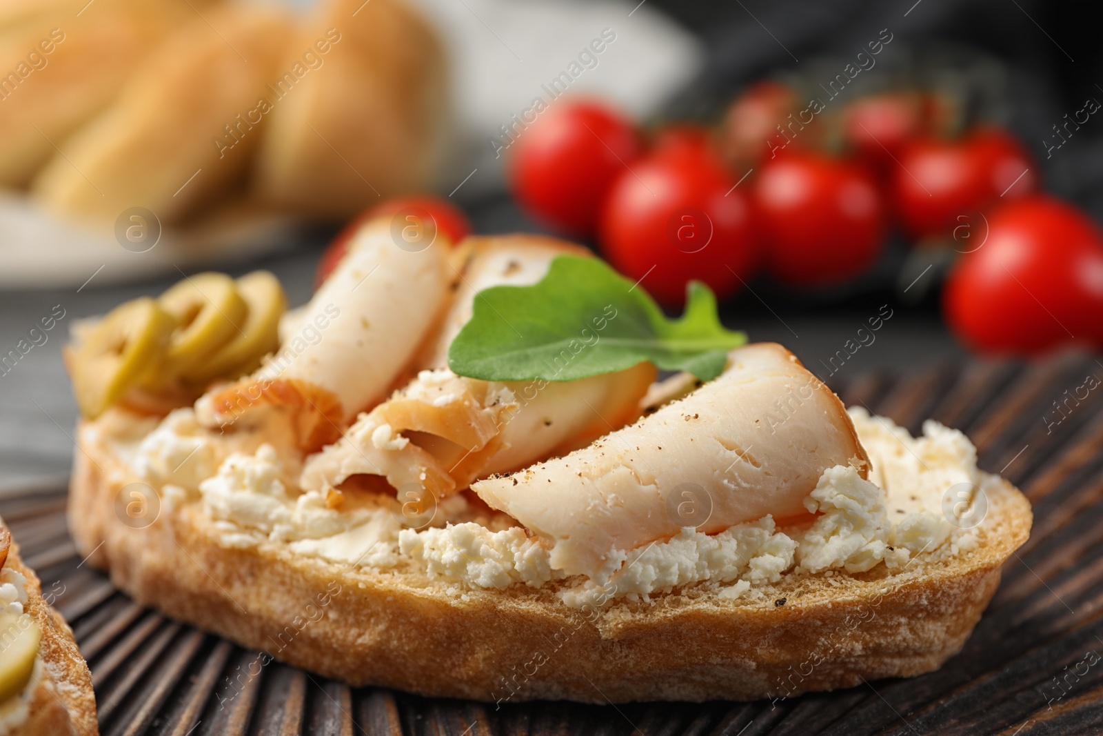 Photo of Board with delicious chicken bruschetta on table, closeup