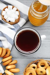 Flat lay composition with delicious ring shaped Sushki (dry bagels) and mug of tea on light grey wooden table