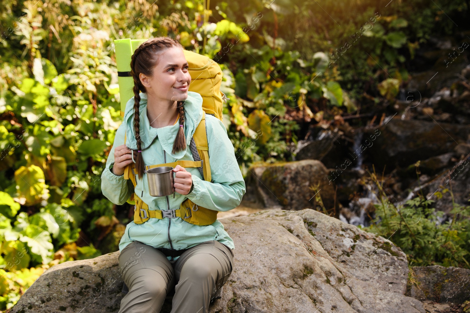 Photo of Tourist with backpack and mug of hot drink resting outdoors