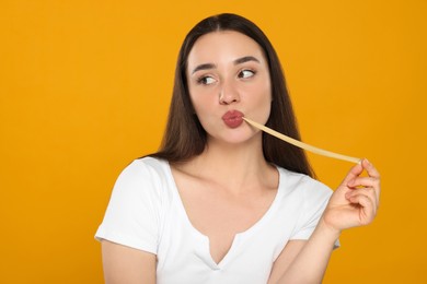 Photo of Happy young woman with bubble gum on yellow background