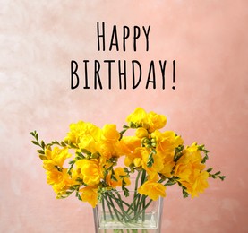 Image of Happy Birthday! Beautiful yellow freesia flowers in glass vase against pink background