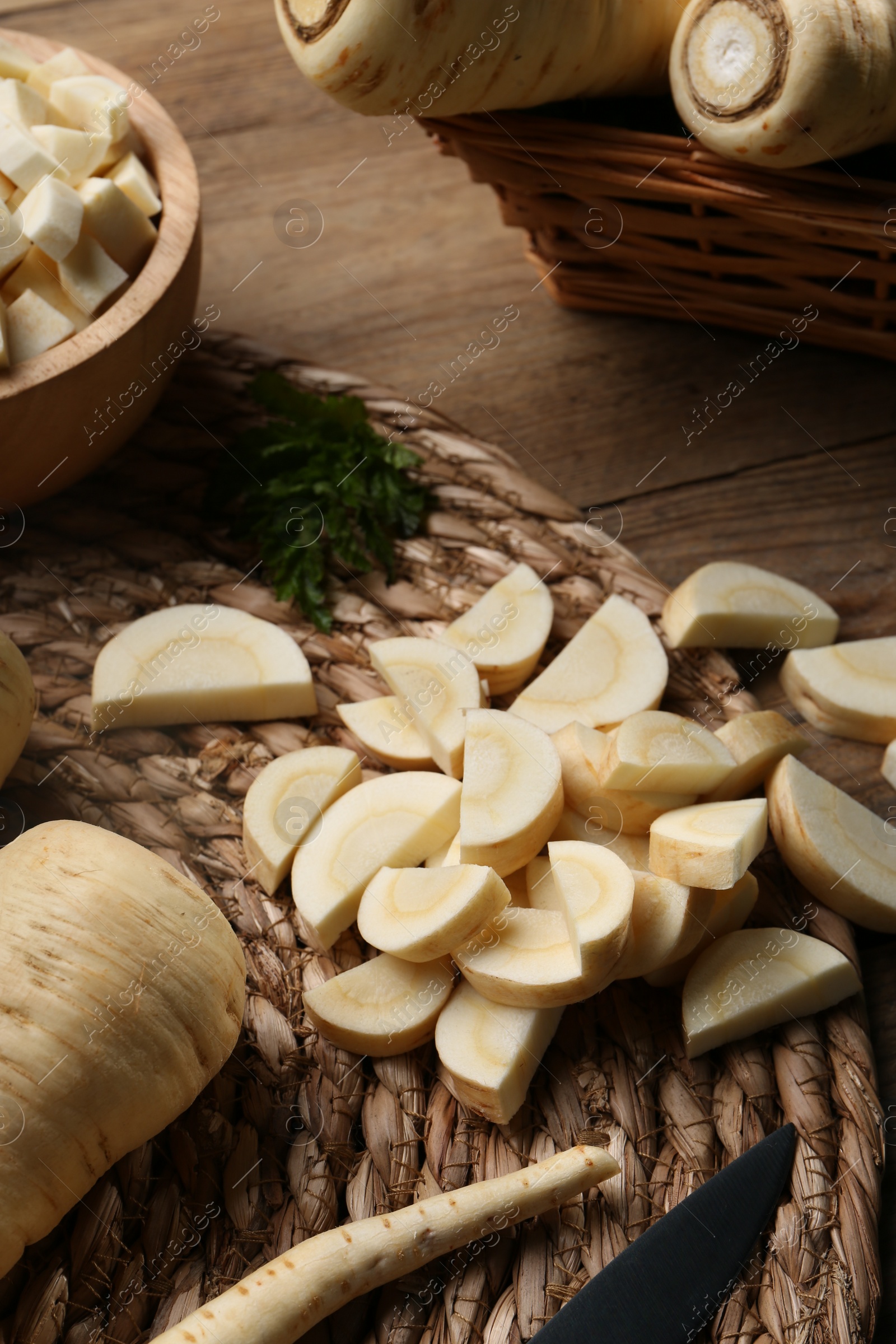 Photo of Whole and cut parsnips on wooden table