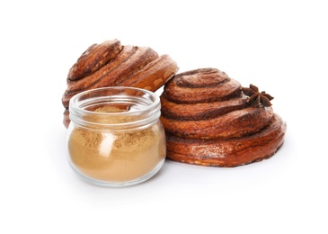 Freshly baked cinnamon rolls with ingredients on white background