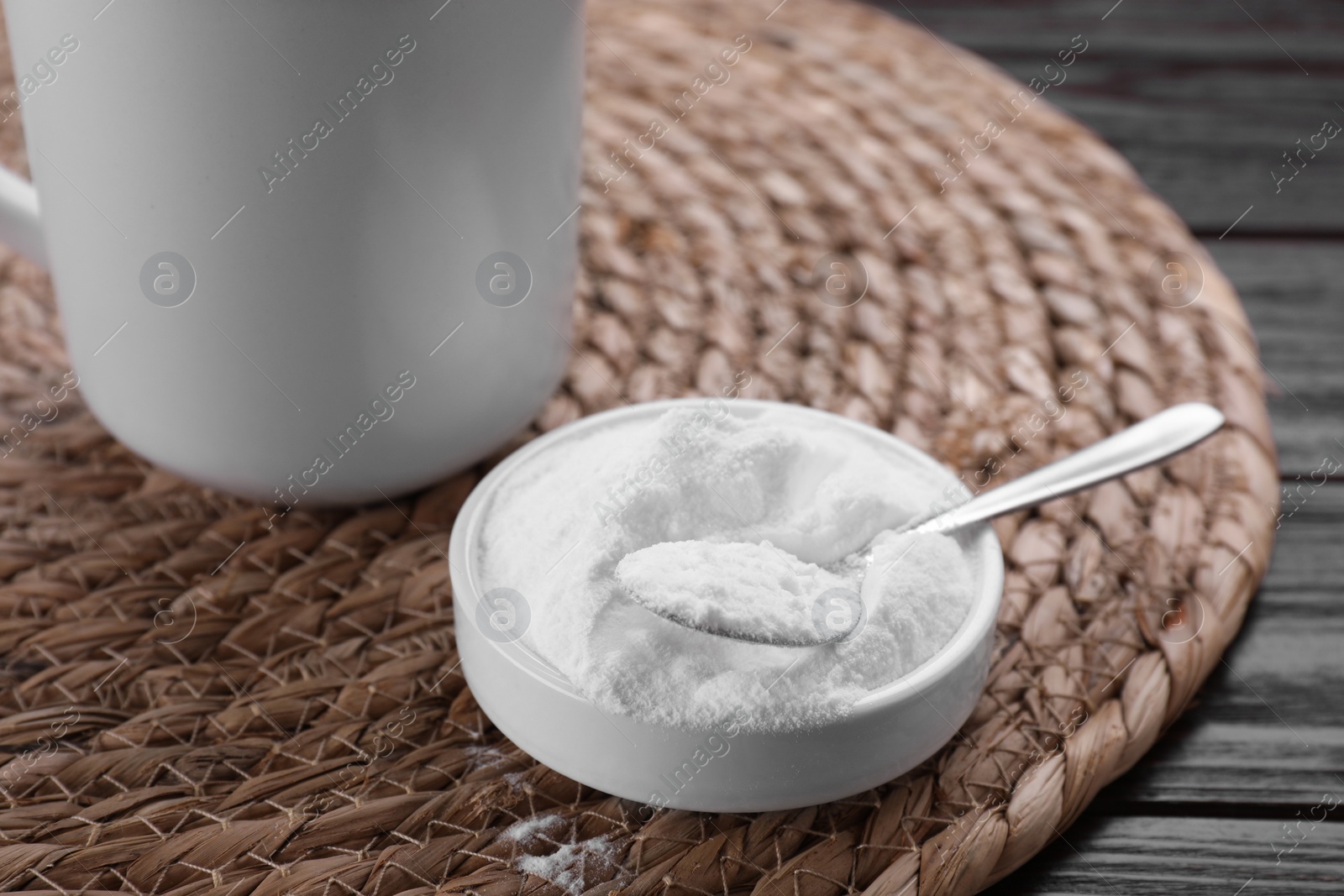 Photo of Bowl of fructose powder and cup with drink on dark wooden table, closeup