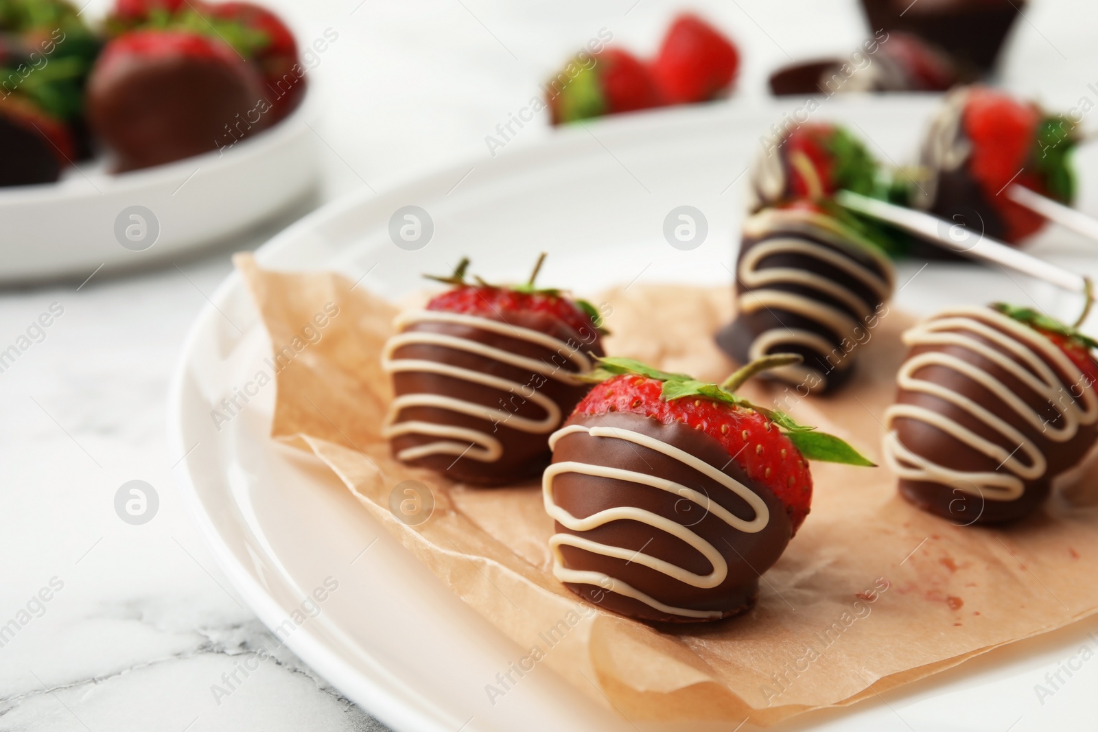 Photo of Plate with chocolate covered strawberries on table, closeup