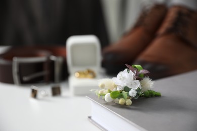 Photo of Wedding stuff. Composition with stylish boutonniere on white surface, closeup