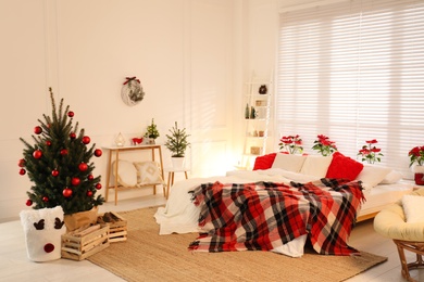 Photo of Beautiful decorated Christmas tree in bedroom. Interior design