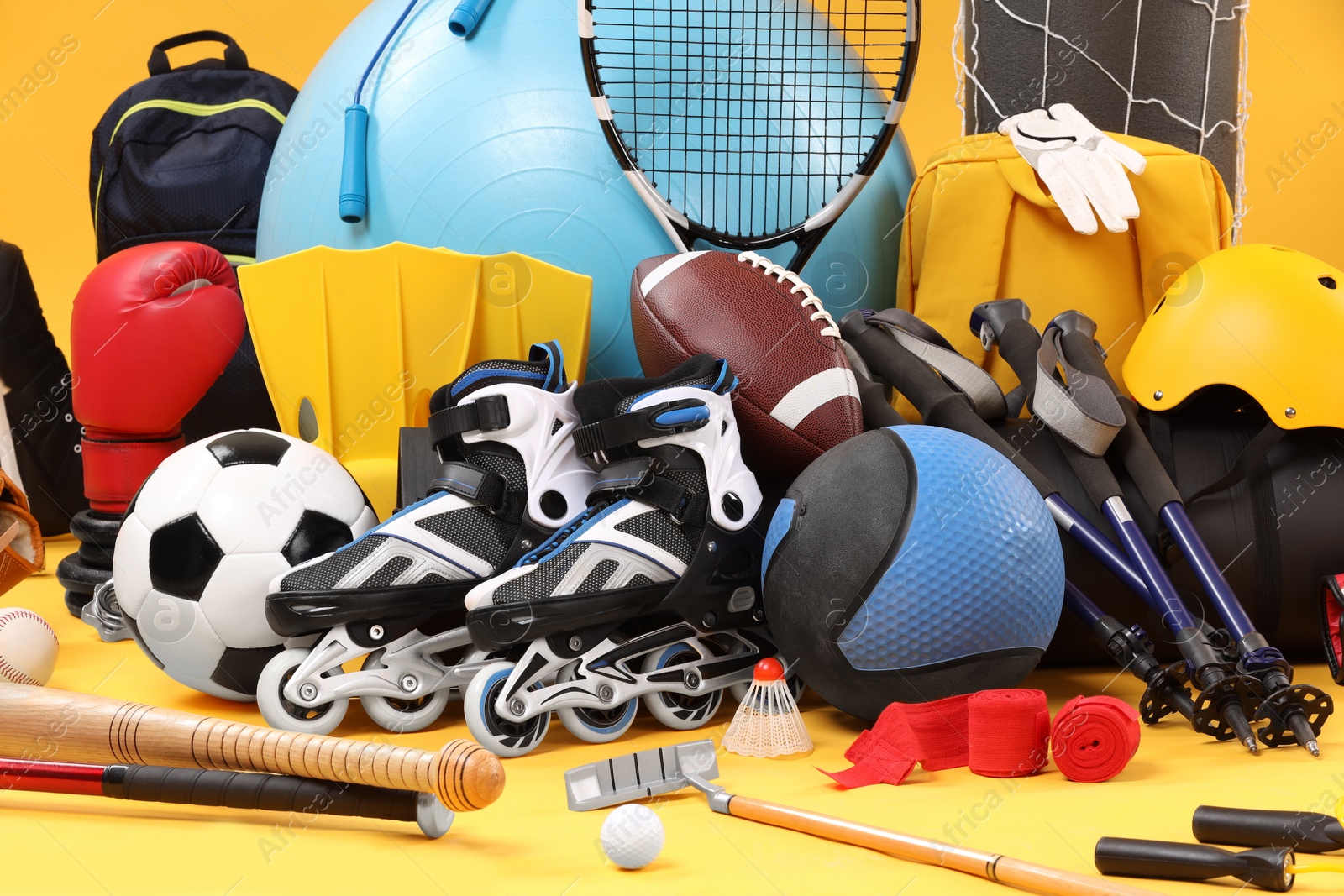 Photo of Many different sports equipment on yellow background