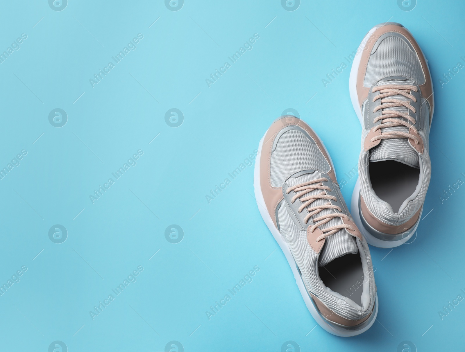 Photo of Pair of stylish sneakers on color background, top view. Space for text