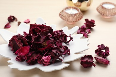 Photo of Aromatic potpourri of dried flowers in plate on table