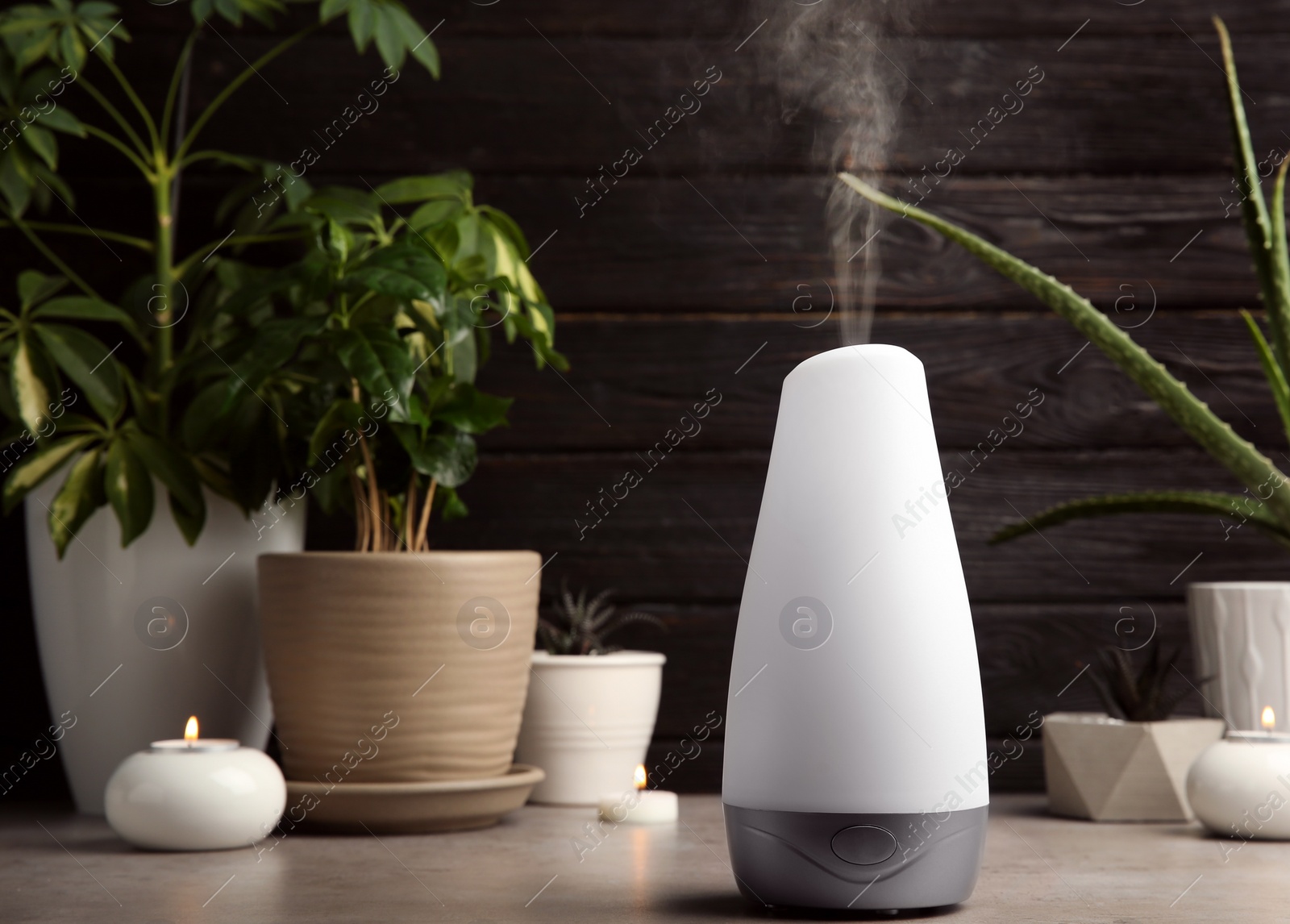 Photo of Composition with modern aroma humidifier on table against dark wooden background, space for text