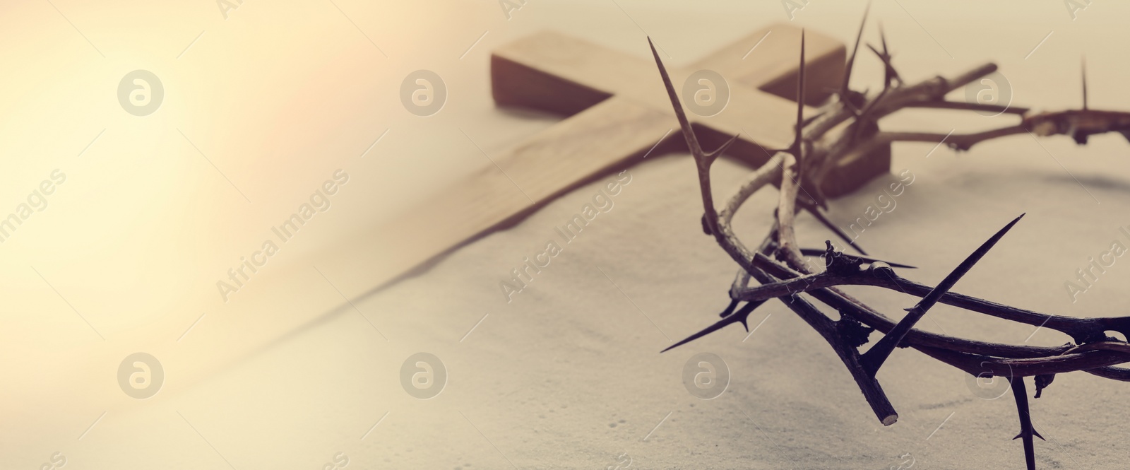 Image of Passion Of Jesus Christ. Crown of thorns and wooden cross on sand, banner design