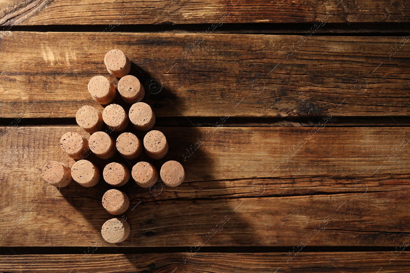 Photo of Christmas tree made of wine corks on wooden table, top view. Space for text