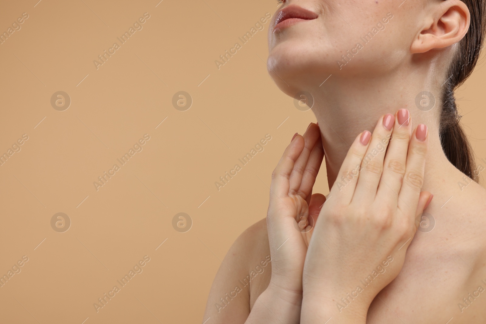 Photo of Woman touching her neck on beige background, closeup. Space for text