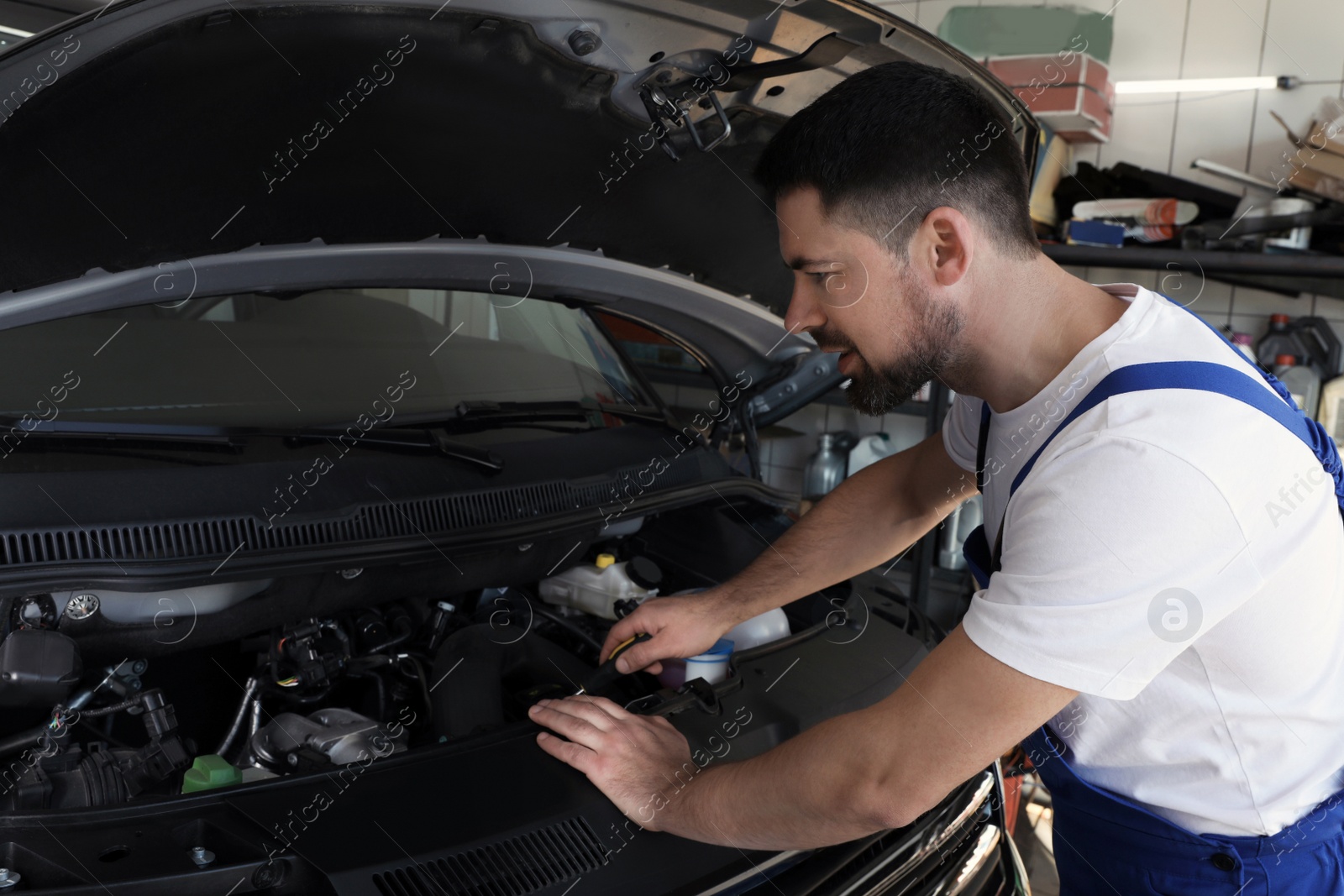 Photo of Professional auto mechanic fixing modern car in service center