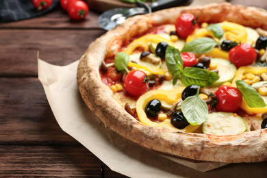 Photo of Tasty vegetable pizza on wooden table, closeup