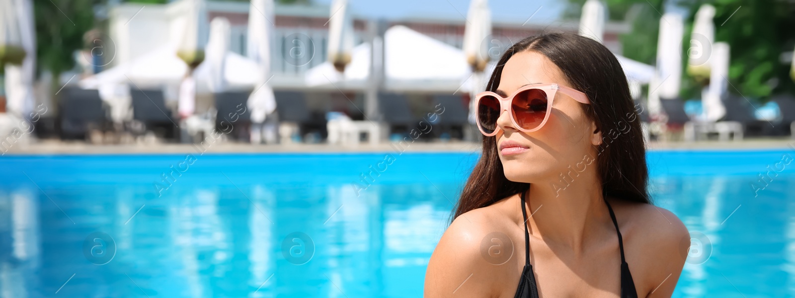 Image of Beautiful young woman in swimming pool on sunny day, banner design