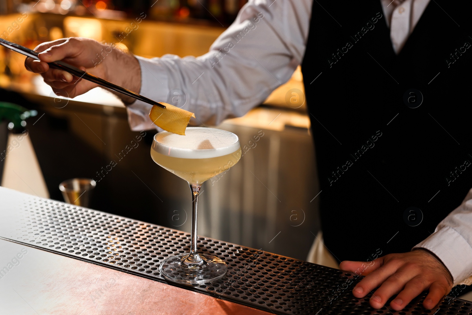 Photo of Bartender making fresh alcoholic cocktail at bar counter, closeup