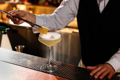 Bartender making fresh alcoholic cocktail at bar counter, closeup