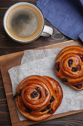 Delicious pastries and coffee on wooden table, flat lay