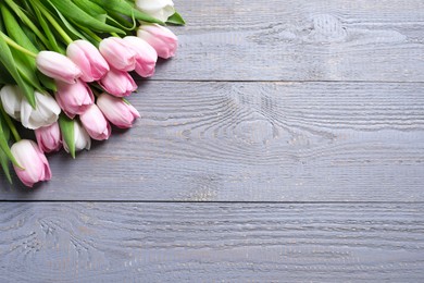 Photo of Beautiful pink spring tulips on grey wooden background, flat lay. Space for text