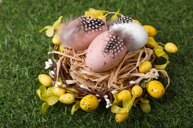 Photo of Festively decorated Easter eggs on green grass, closeup