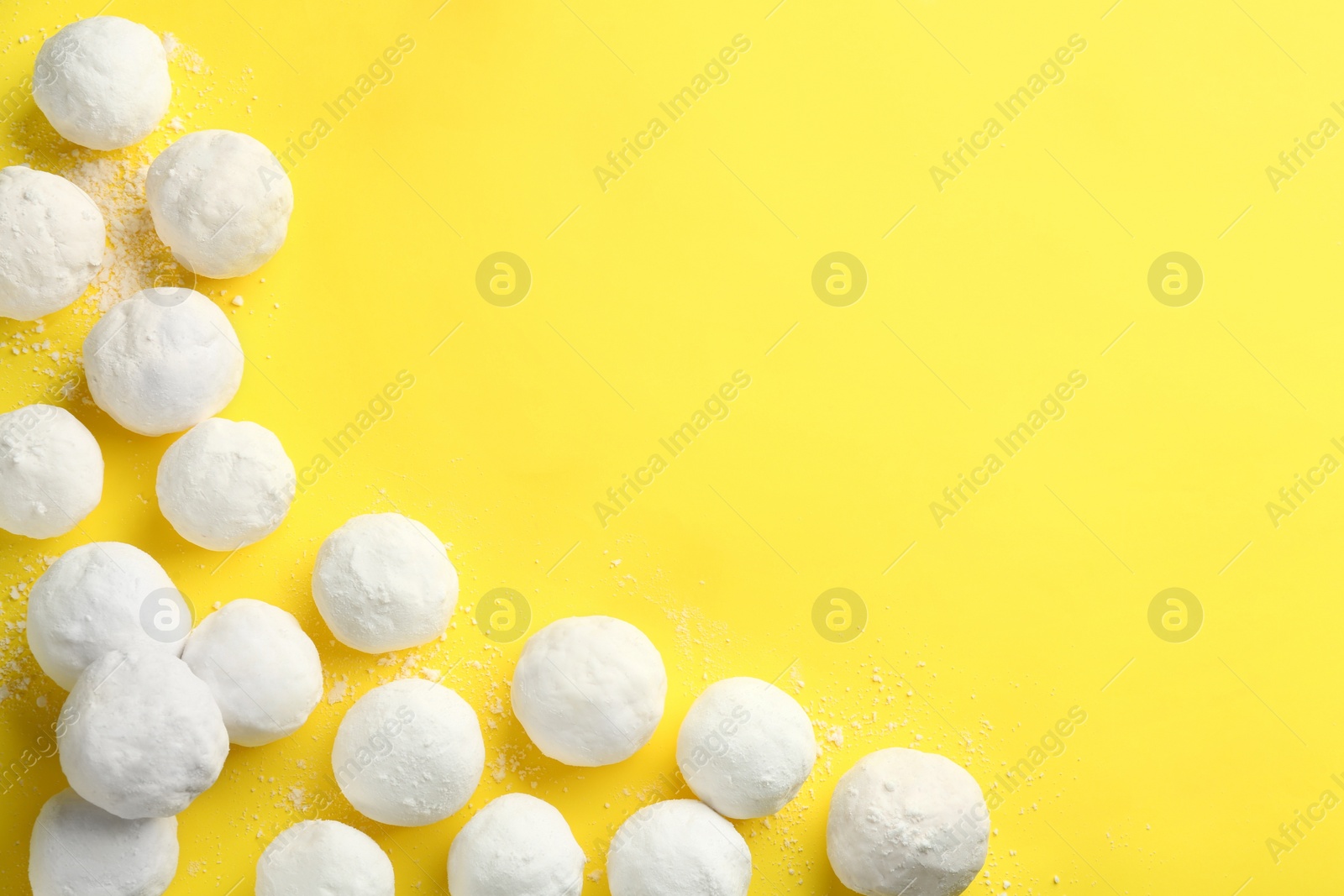 Photo of Snowballs on yellow background, flat lay. Space for text