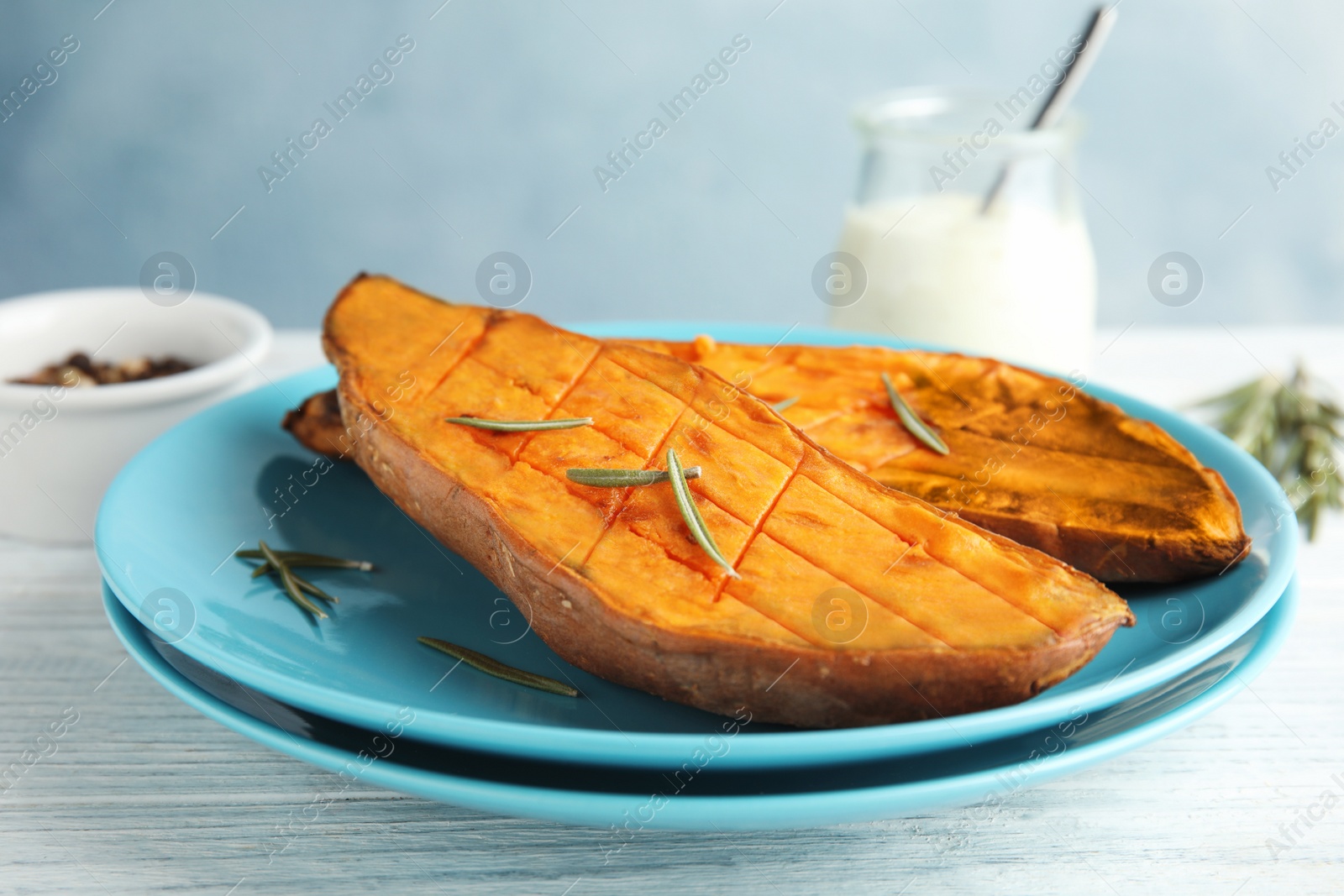 Photo of Plate with baked sweet potato on white wooden table, closeup