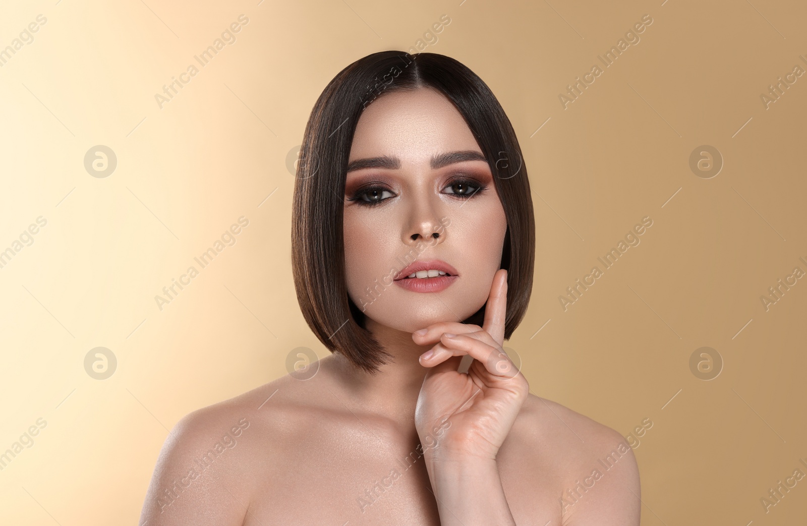 Image of Portrait of pretty young woman with brown hair on beige background