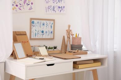 Photo of Stylish room interior with creative workplace near white wall