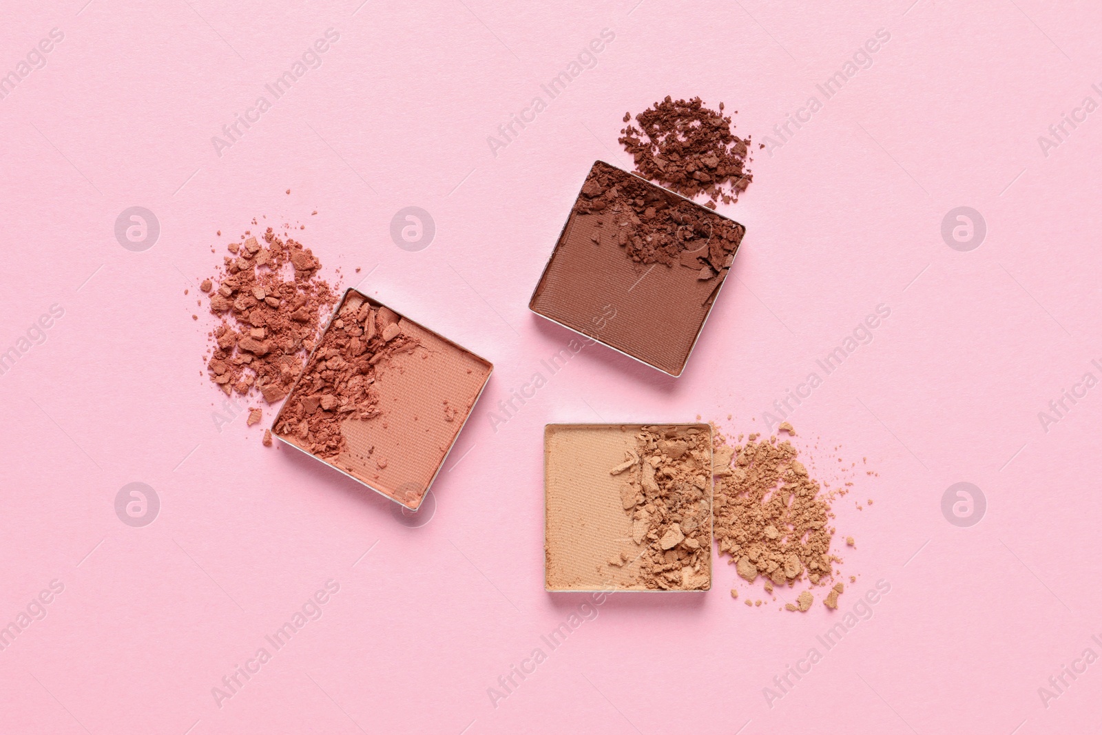 Photo of Crushed eye shadows on pink background, flat lay. Professional makeup product