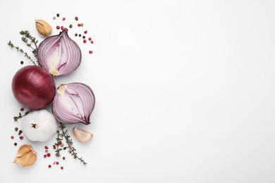 Photo of Fresh red onions, garlic, thyme and spices on white background, flat lay. Space for text