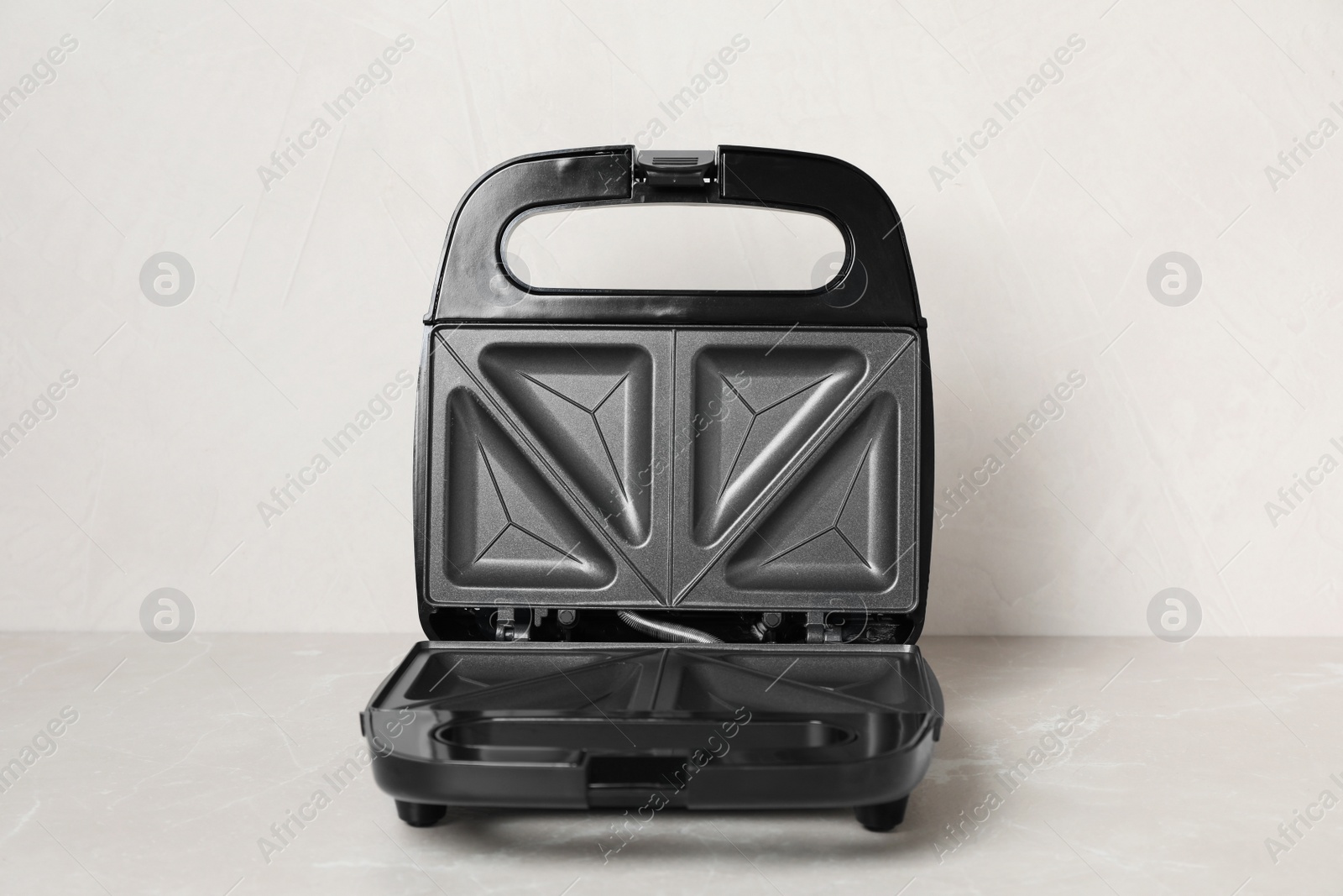 Photo of Open modern sandwich maker on light grey table