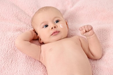 Photo of Cute little baby with cream on face on pink blanket, above view