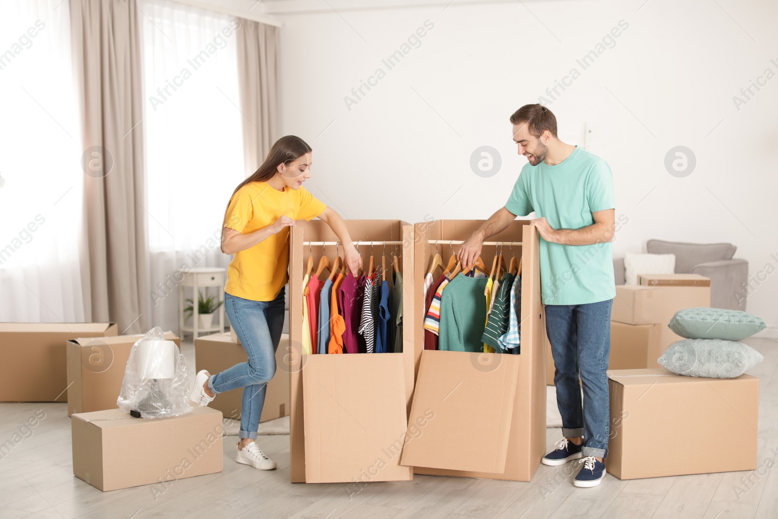 Photo of Young couple near wardrobe boxes at home