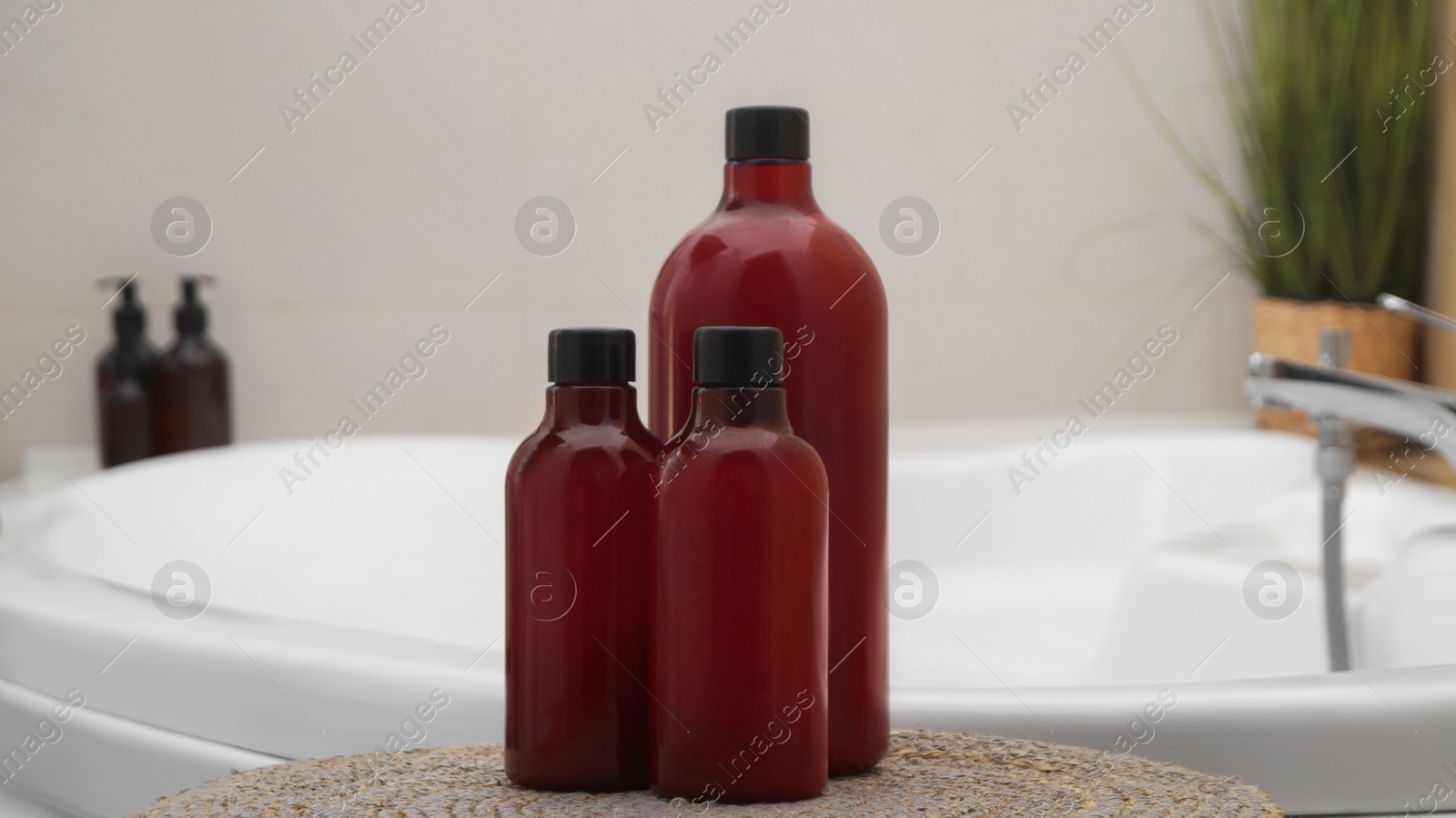 Photo of Bath foam and other personal hygiene products in bottles on wicker mat in bathroom