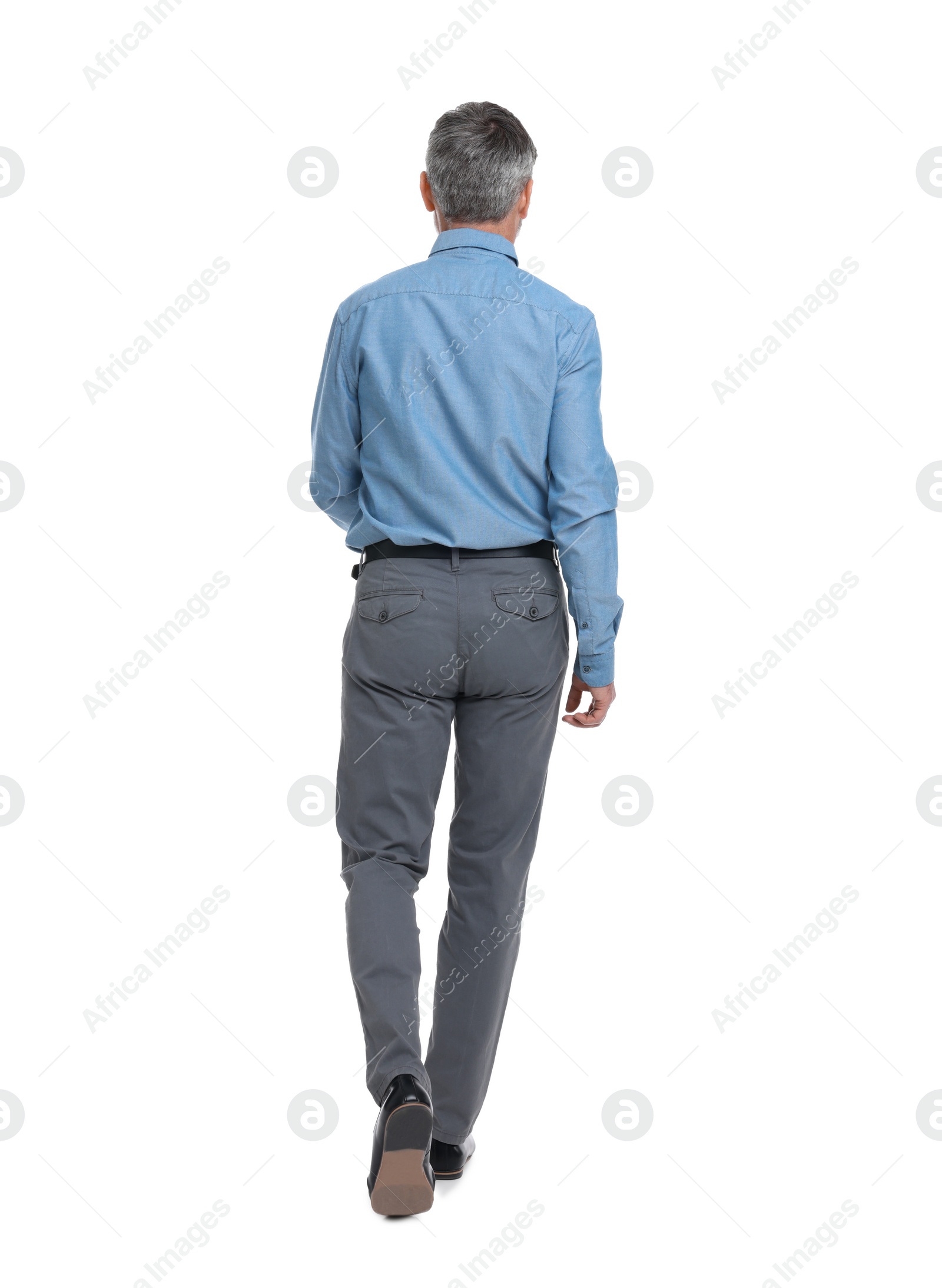 Photo of Mature businessman in stylish clothes walking on white background, back view