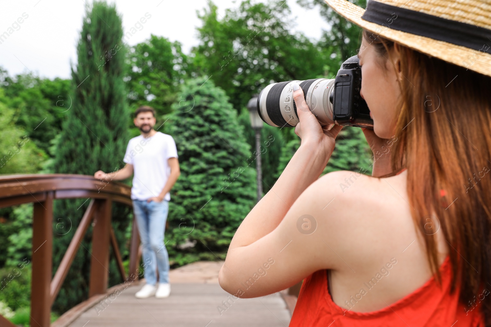 Photo of Photographer taking photo of man with professional camera in park