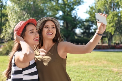 Young women taking selfie outdoors on sunny day