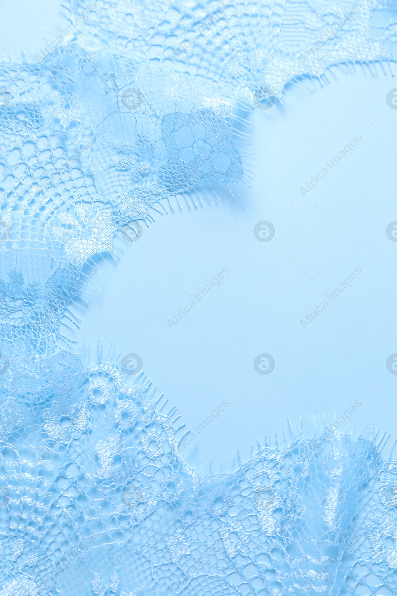 Photo of Beautiful lace on light blue background, top view. Space for text