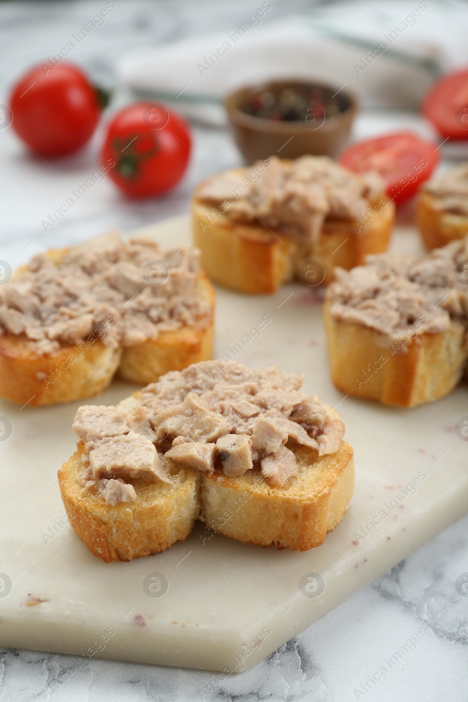 Photo of Tasty sandwiches with cod liver on white marble table