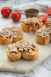 Photo of Tasty sandwiches with cod liver on white marble table