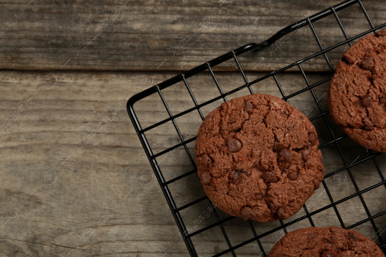 Photo of Delicious chocolate chip cookies on wooden table, top view. Space for text