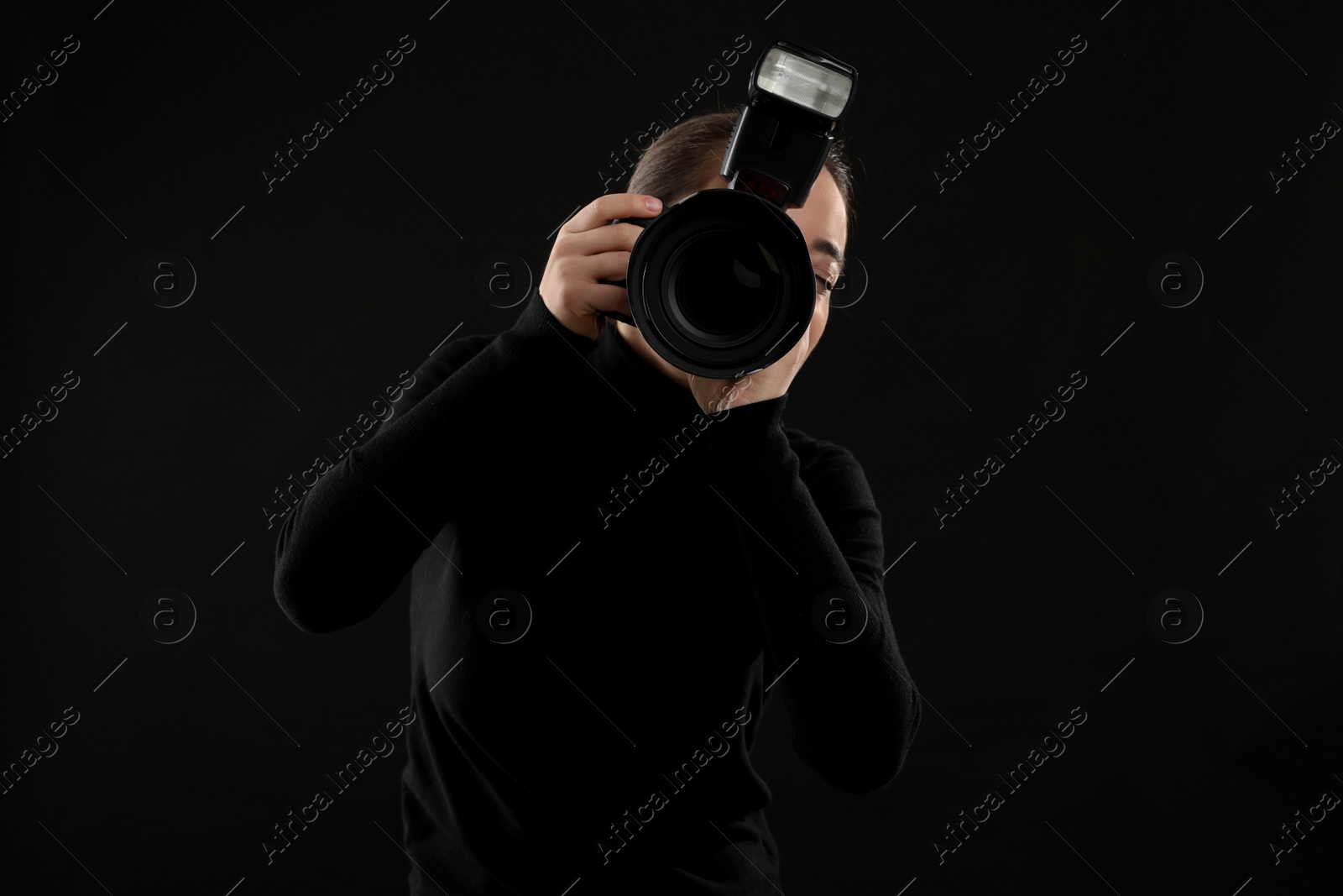 Photo of Professional photographer taking picture on black background