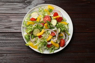 Photo of Tasty fresh vegetarian salad on dark wooden table, top view