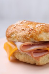 Photo of Delicious bagel with ham and cheese on plate, closeup